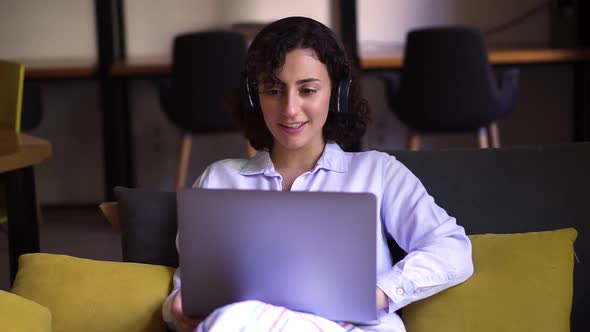 Portrait of Curly Brunette Woman Working on Laptop at Home Office