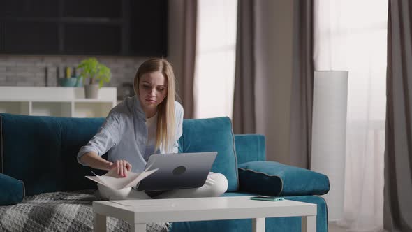 Excited Young Woman Winner Looks at Laptop Celebrates Online Success Sits on Sofa at Home