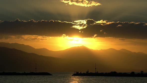 Sun flares bursting through clouds at sunset