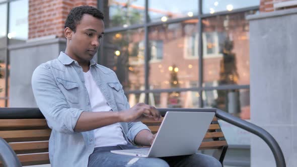 African Man Leaving Bench After Closing Laptop