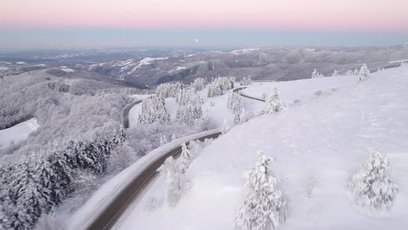 Aerial View of Winter Mountain Road with Beautiful Snowy Valley Below