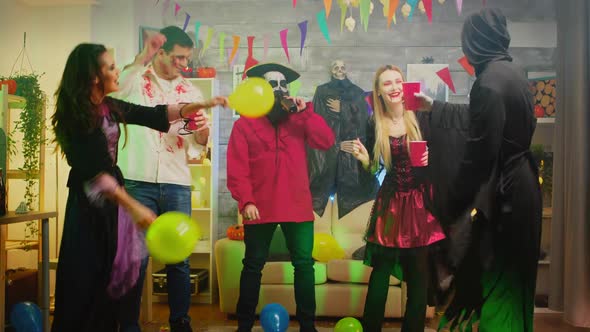 Group of People Dancing and Having Fun at Halloween Party in a Decorated House