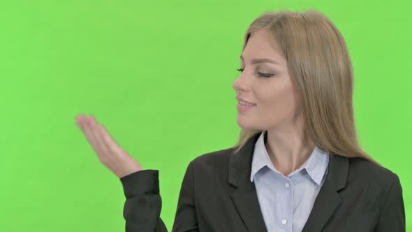 Cheerful Businesswoman Showing Open Hand Palm Against Chroma Key