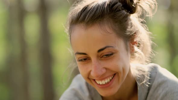 Laughing Young Adult European Woman Looking at Camera Standing in Woods