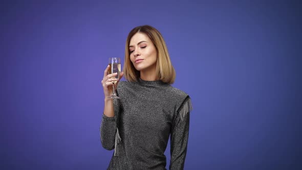 Woman in Silver Shirt Holding Glass of Champagne and Smiling