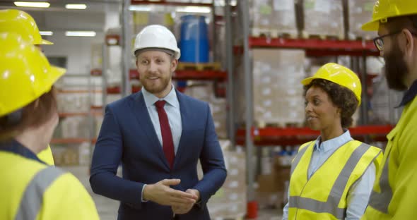 Young Handsome Businessman Having Meeting with Warehouse Workers