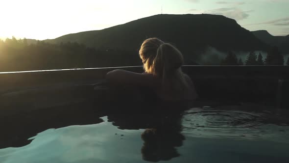 Woman Relaxing In Hot Tub And Looking At Sunset