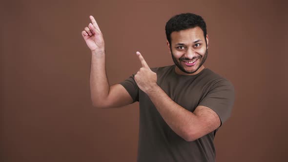 Emotional Indian Man Pointing Upward with Enjoyment Nodding Head As Approval Brown Studio Background