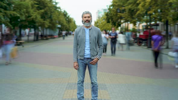 Zoomin Time Lapse Portrait of Confident Mature Guy Standing Outdoors in Street Among Crowd of People