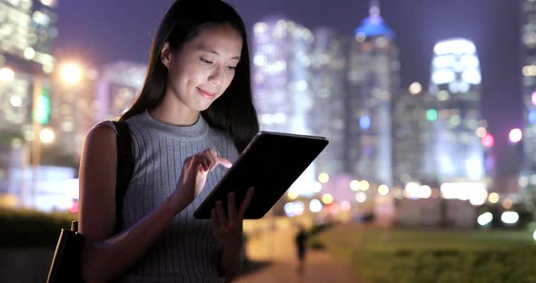 Woman Using Tablet Computer in Hong Kong City at Night 