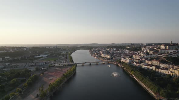 Mondego river with fountain and water games, Coimbra, Portugal. Aerial backward