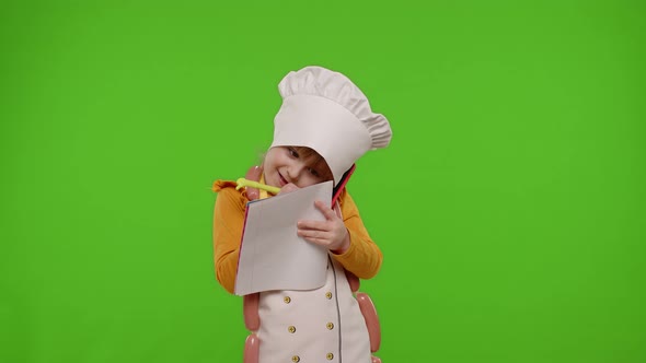 Girl Kid Cook Chef Receiving Online Order Writing with Pen in Notebook Talking on Mobile Phone