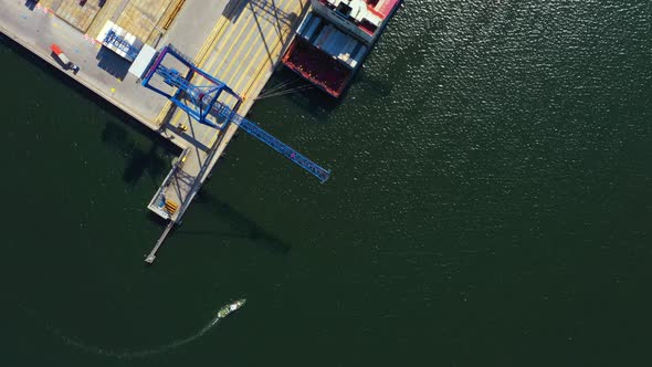 Container ship in export and import business and logistics. Shipping cargo to harbor by crane. Water