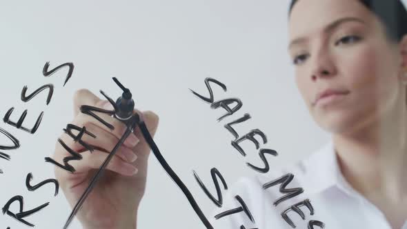 Businesswoman Drawing Graph on Transparent Wall