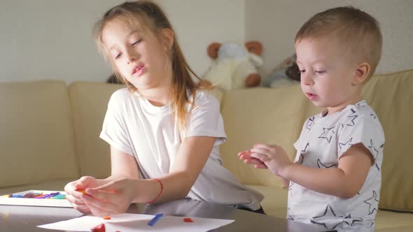 Two Child, Old Sister and Little Brother Playing with Plasticine at Home.