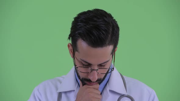 Face of Stressed Young Bearded Persian Man Doctor Thinking and Looking Down