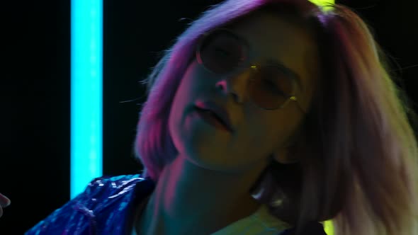 Portrait of a Young Stylish Woman in Sunglasses Dancing and Chewing Gum. Close Up. Slow Motion.