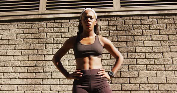 Portrait of african american woman exercising outdoors looking to camera and breathing deeply