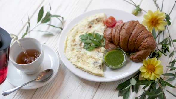 Breakfast with Fresh Croissant and Omelet. Breakfast Stands on a Wooden White Background with