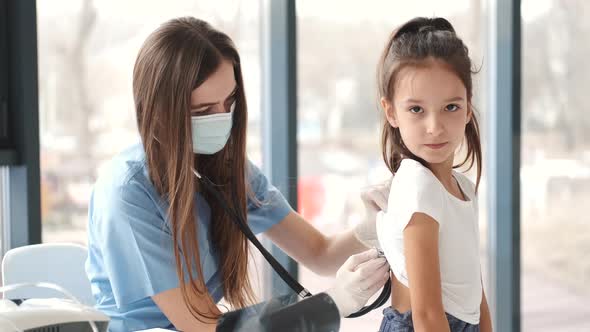 Female Doctor Examining Girl's Breathing with Stethoscope