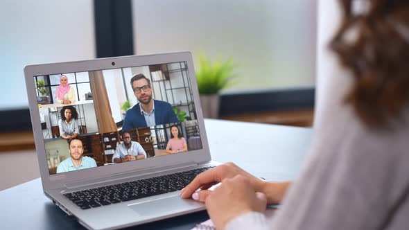 Young Woman Using a Laptop for Video Connection with Diverse Group of People