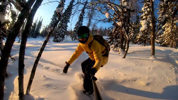 Professional snowboarder creating snow cloud riding on snowboard. Rider having fun doing tricks