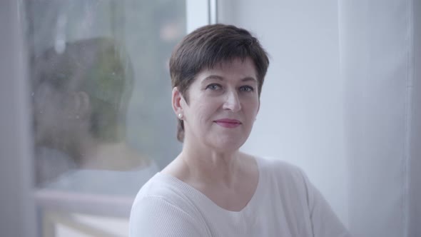 Close-up Portrait of Confident Brunette Middle-aged Caucasian Woman Indoors. Beautiful Elegant Lady