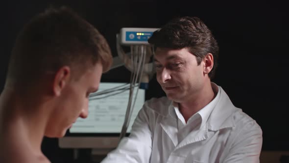 Doctor Placing Electrodes on Male Patient