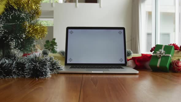 Close up of laptop with copy space on screen, sitting on table in living room at christmas