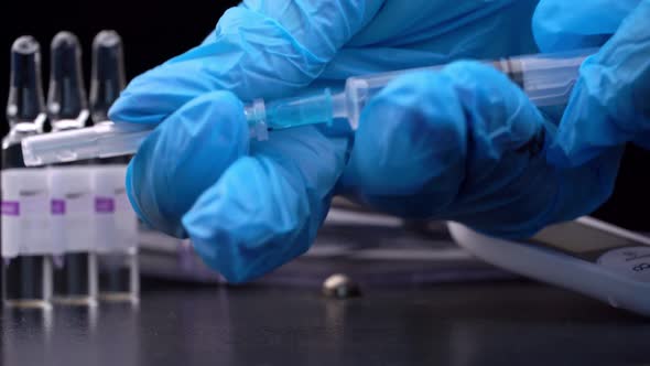 Nurse Prepares a Syringe And Medicine Drips From It in Large Drops Closeup