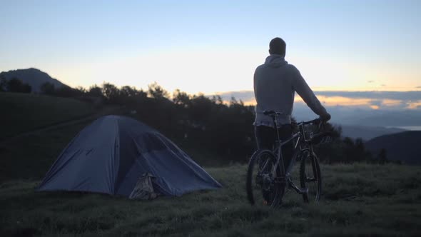 Young Man with Mountain Bike in Nature Outdoor Wait for Sunrise or Sunset Dolly