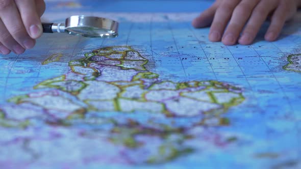 Person Looking at Africa on Map Through Magnifying Glass, Trip Destination