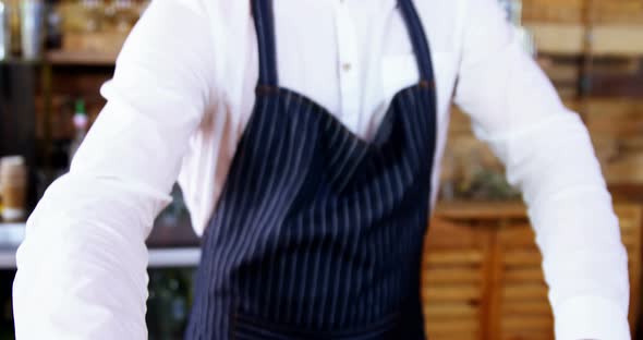 Portrait of waiter serving coffee at counter