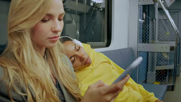 Girl Falls Asleep in Modern Metro Train and Falls on a Woman's Shoulder