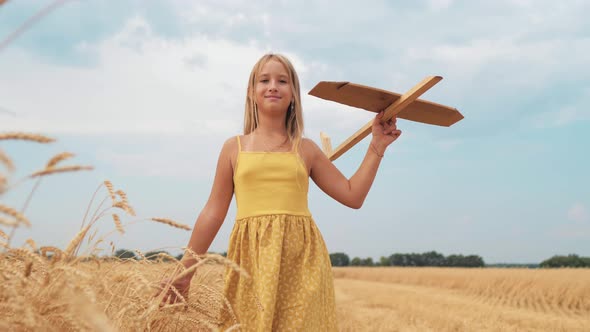 Happy Girl Child Run on Wheat Field with an Airplane