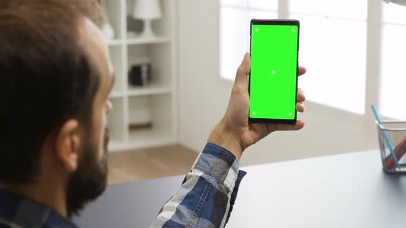 Man Looking at Phone with Green Screen