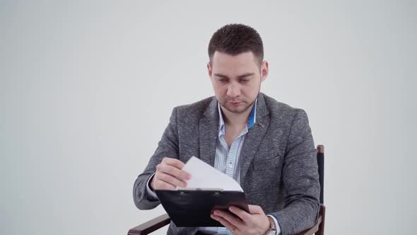 Handsome man in grey costume holding a folder