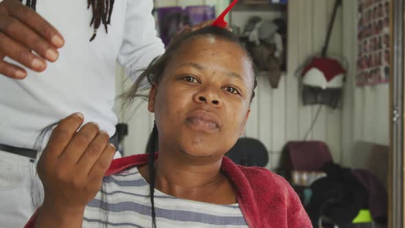 African woman having her hair styled