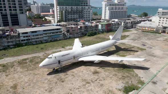 Aerial pullback from White old Aircraft parked in Pattaya city centre, Runaway 88 street project, Th