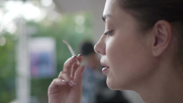 Woman Smoking a Cigarette Outdoors 