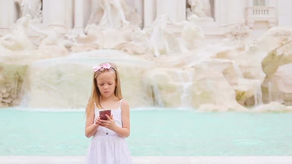 Little Girl with Smart Phone at Warm Day Outdoors