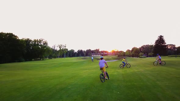 Happy Students Riding Bikes in the Park