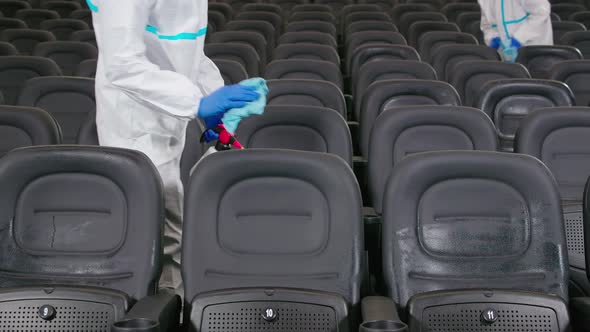 Workers Cleaning Chairs with Disinfectants in Cinema