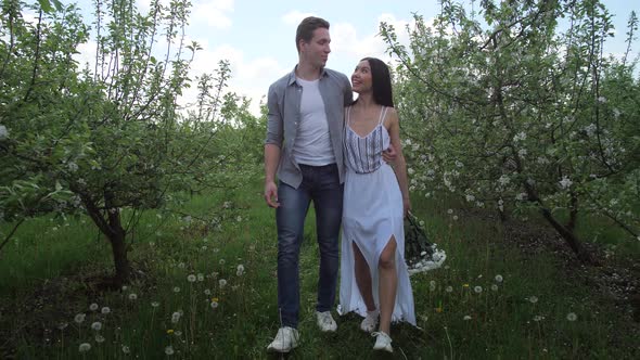 Mixed Race Couple Laughing Walking in Orchard