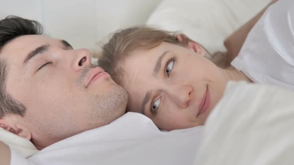 Thinking Woman Lying in Bed Cuddling Sleeping Boyfriend