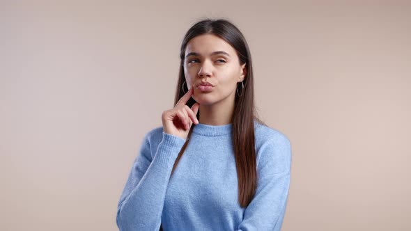 Portrait of Young Thinking Pondering Woman Having Idea Moment Pointing Finger Up on Studio