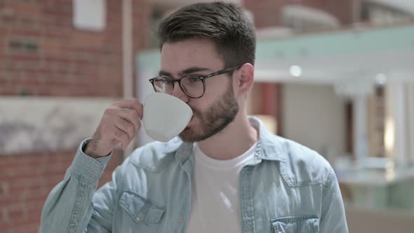 Portrait of Attractive Young Male Designer Drinking Coffee