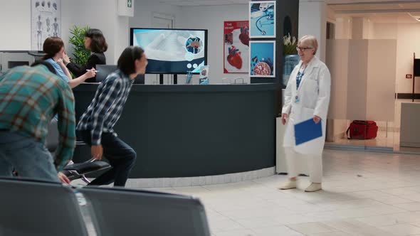 Senior Doctor Taking Asian Patient in Medical Office for Checkup Visit