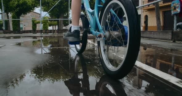 Child Boy Rides a Bike After Rain