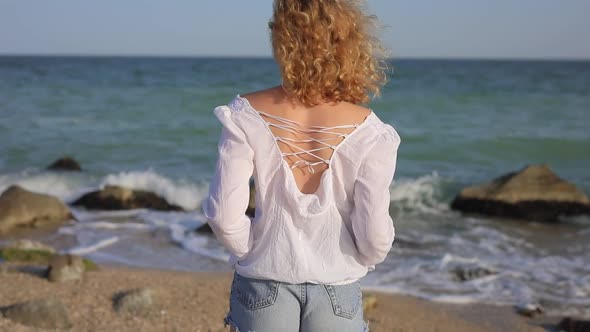 Back View of Woman Looks at the Ocean